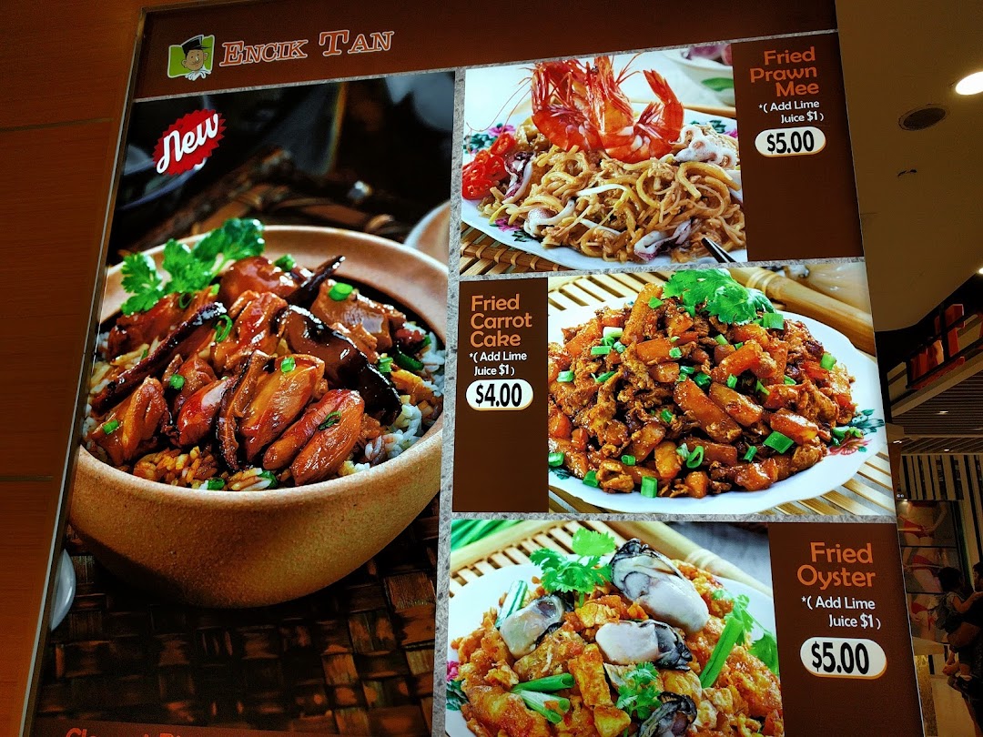 A menu board displaying various food dishes with prices from Encik Tan.