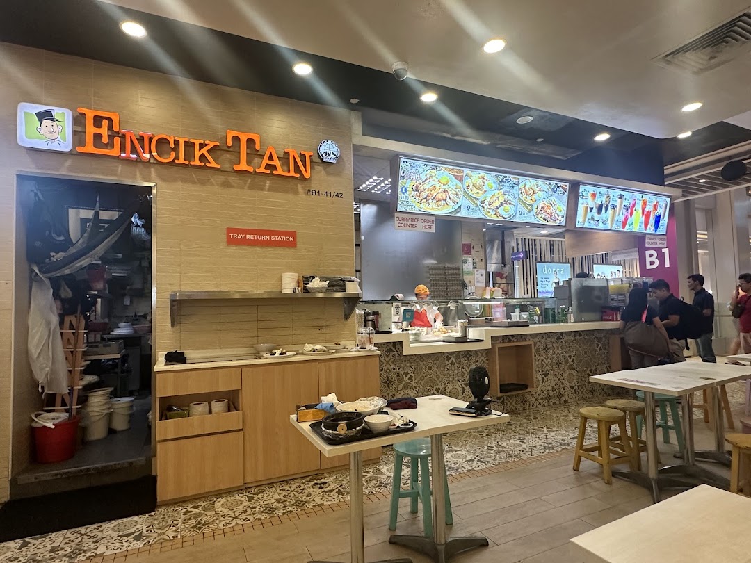 Interior view of Encik Tan food stall with counter, digital menus, and dining area.