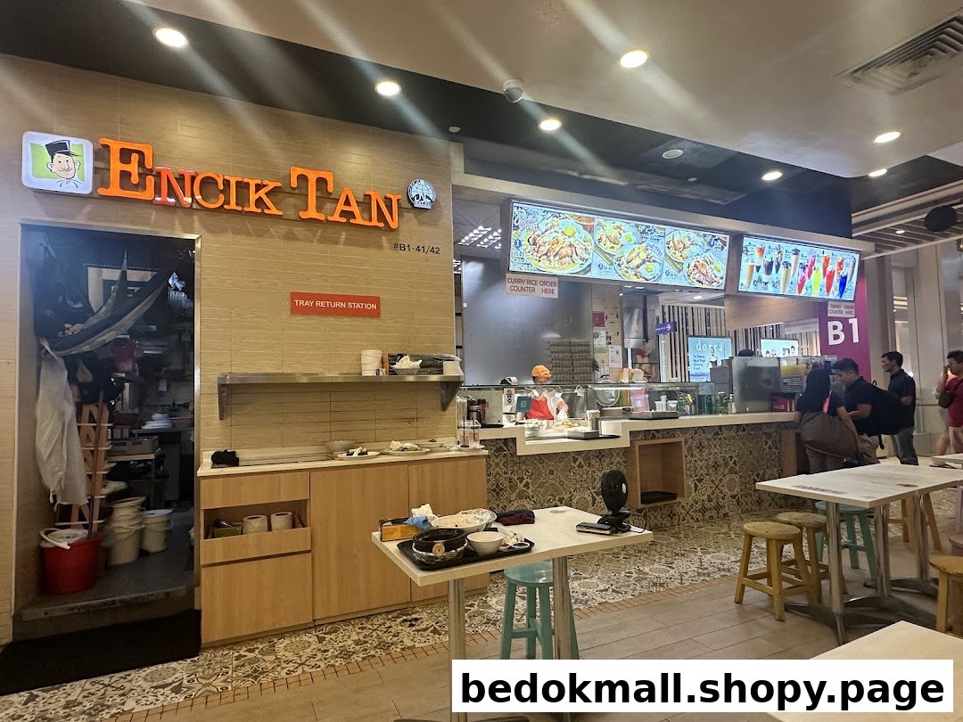 Interior view of Encik Tan food stall with counter, digital menus, and dining area.
