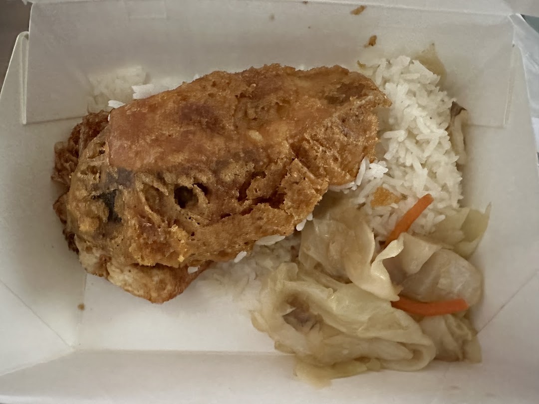 A takeaway meal with fried chicken/omelet, rice, and vegetables in a box.