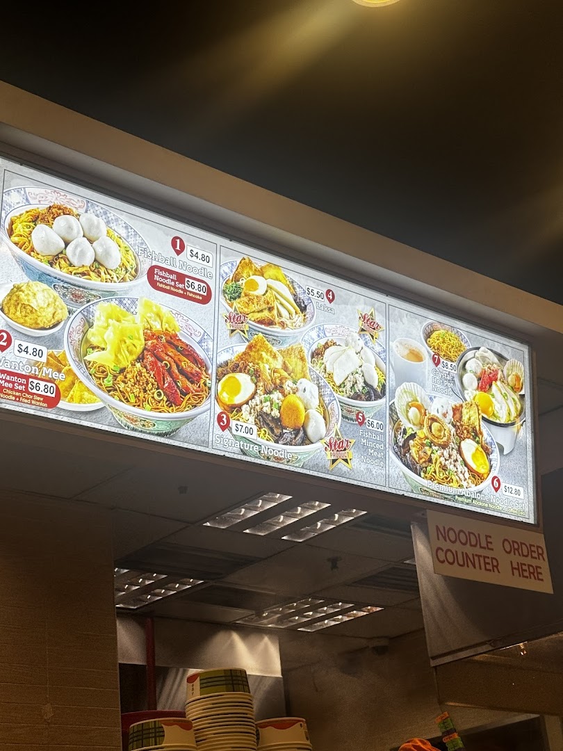 Illuminated menu board displaying various noodle dishes with prices.
