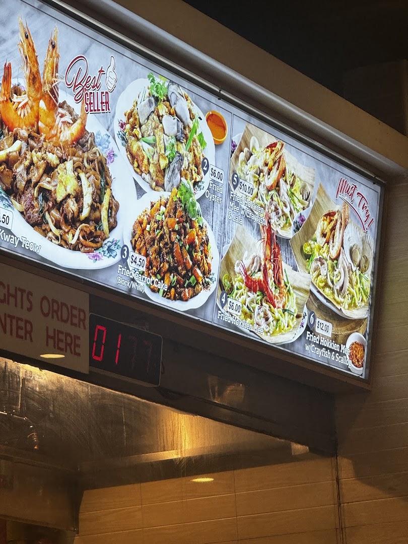 A brightly lit menu board displays various Asian food dishes with prices.