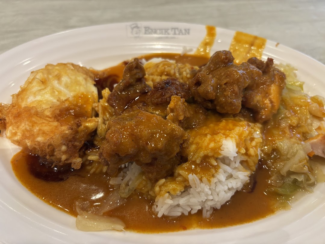 A plate of rice with meat, sauce, and a fried egg.
