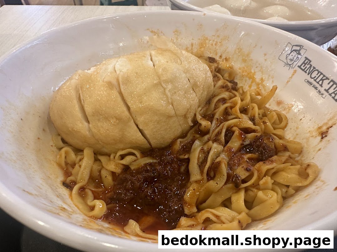 A bowl of noodles with fishcake and sauce from Encik Tan.