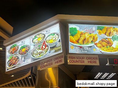 Illuminated food menus with prices and order counter signs.