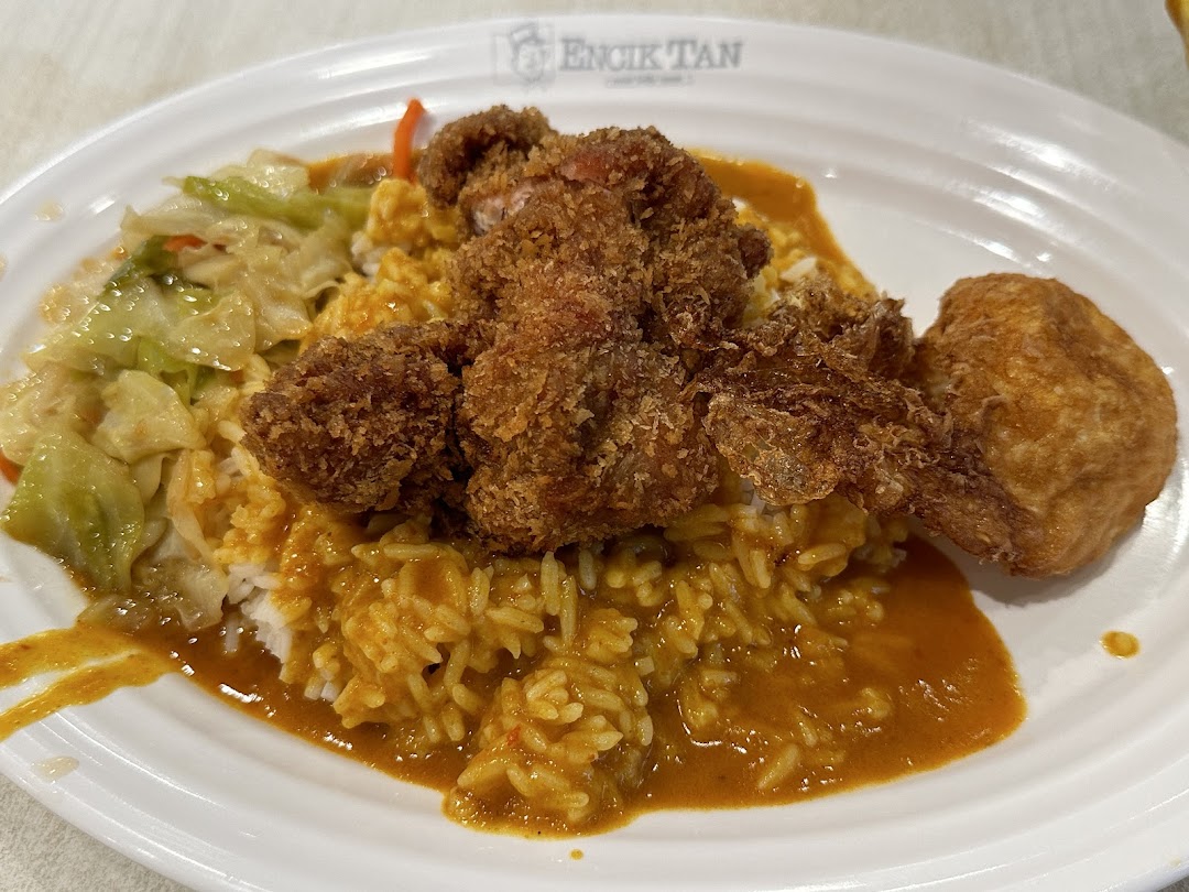 Close-up of a plate with curry rice, fried chicken, and cabbage.