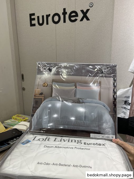 Person holding bedding product packaging with Eurotex logo in background.