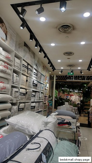 Interior view of a bedding shop with shelves of pillows and duvets.