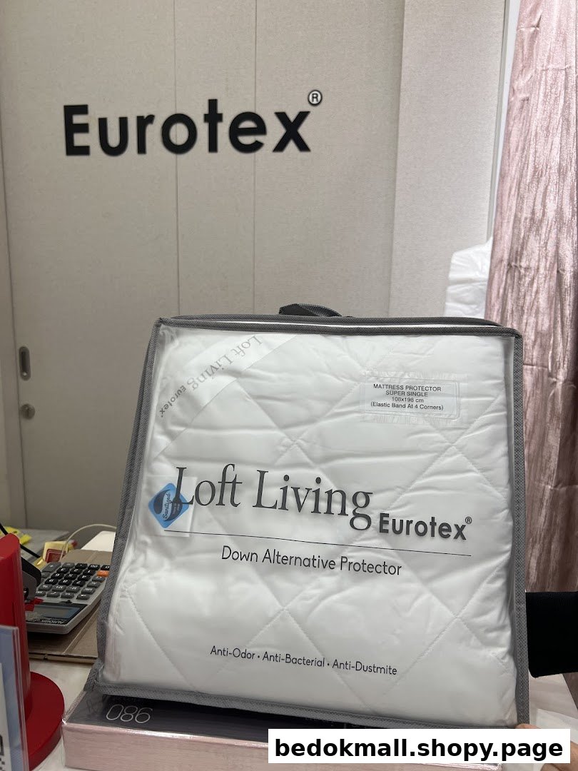 Packaged mattress protector displayed in a Eurotex shop interior.