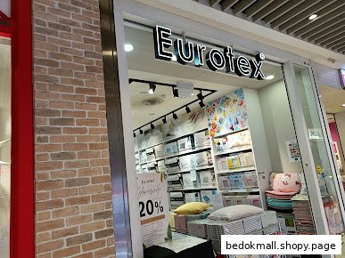 Entrance of Eurotex bedding shop with products and a 20% off sign visible.