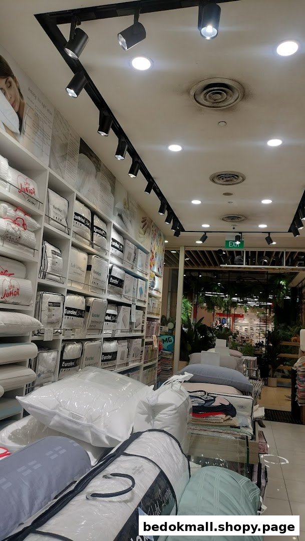 Interior view of a bedding shop with shelves of packaged products and an exit sign.