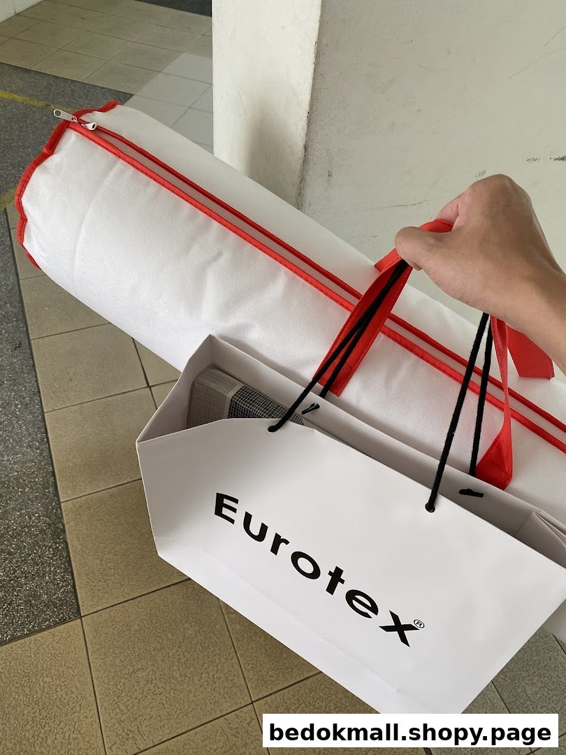 A hand holds a Eurotex shopping bag and a large white cylindrical bag.
