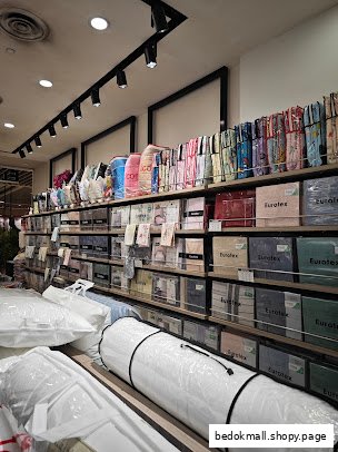 Interior view of a Eurotex shop displaying bedding, pillows, and rolled mattresses.