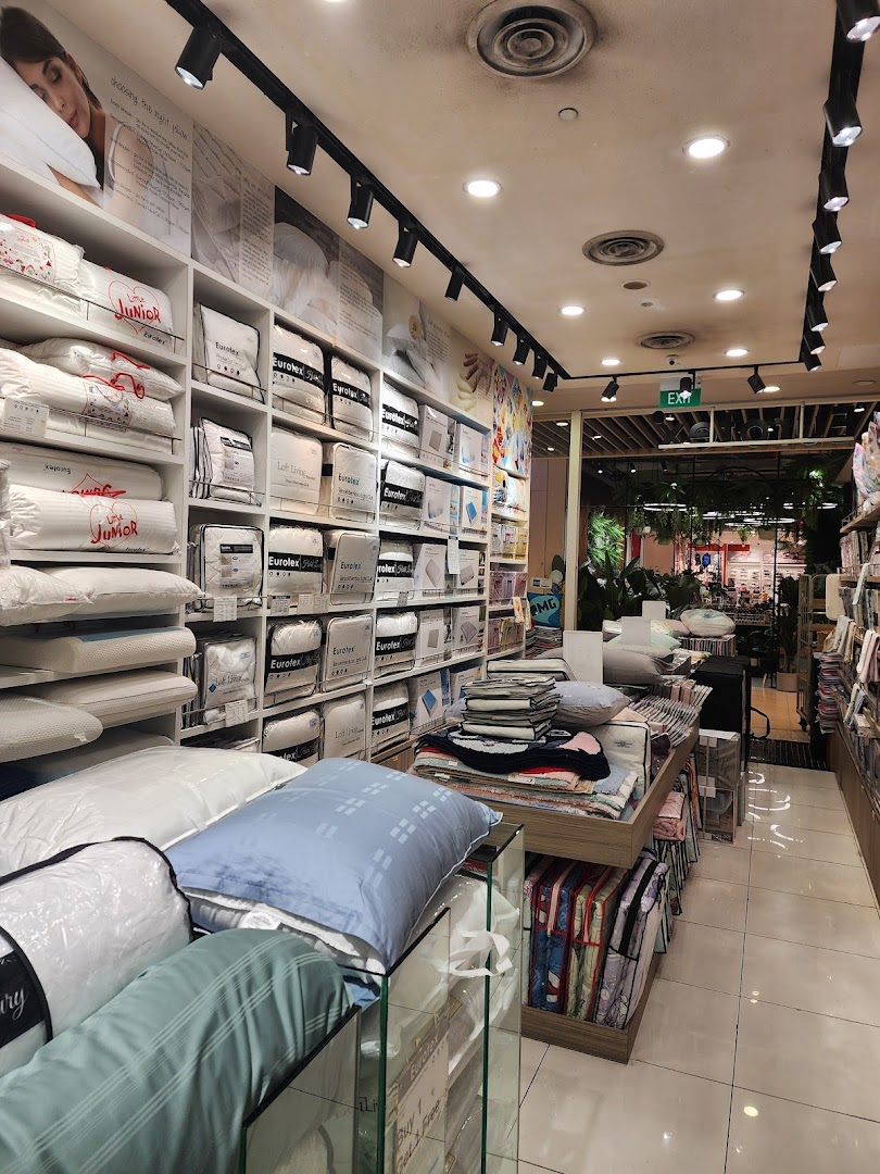 Interior view of a bedding shop with shelves and displays of pillows and linens.