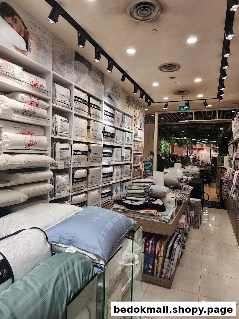Interior view of a bedding shop with shelves and displays of pillows and linens.