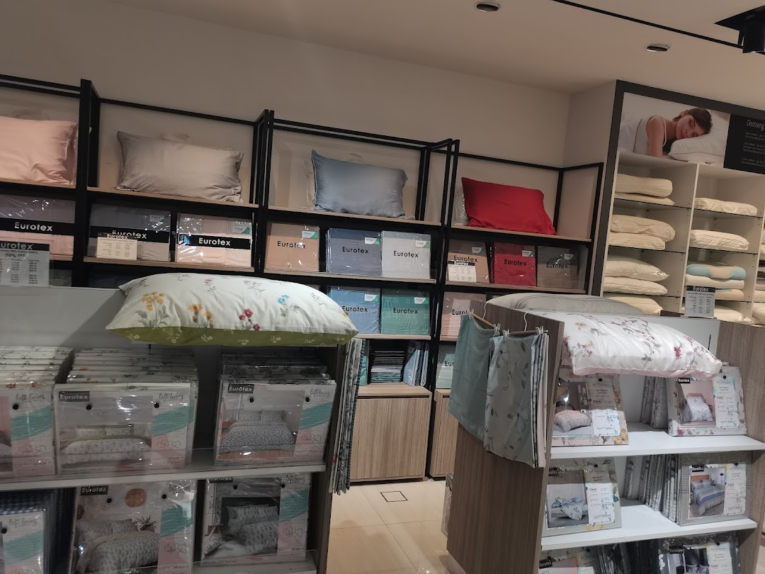 Interior view of a Eurotex bedding shop displaying pillows and packaged sets.