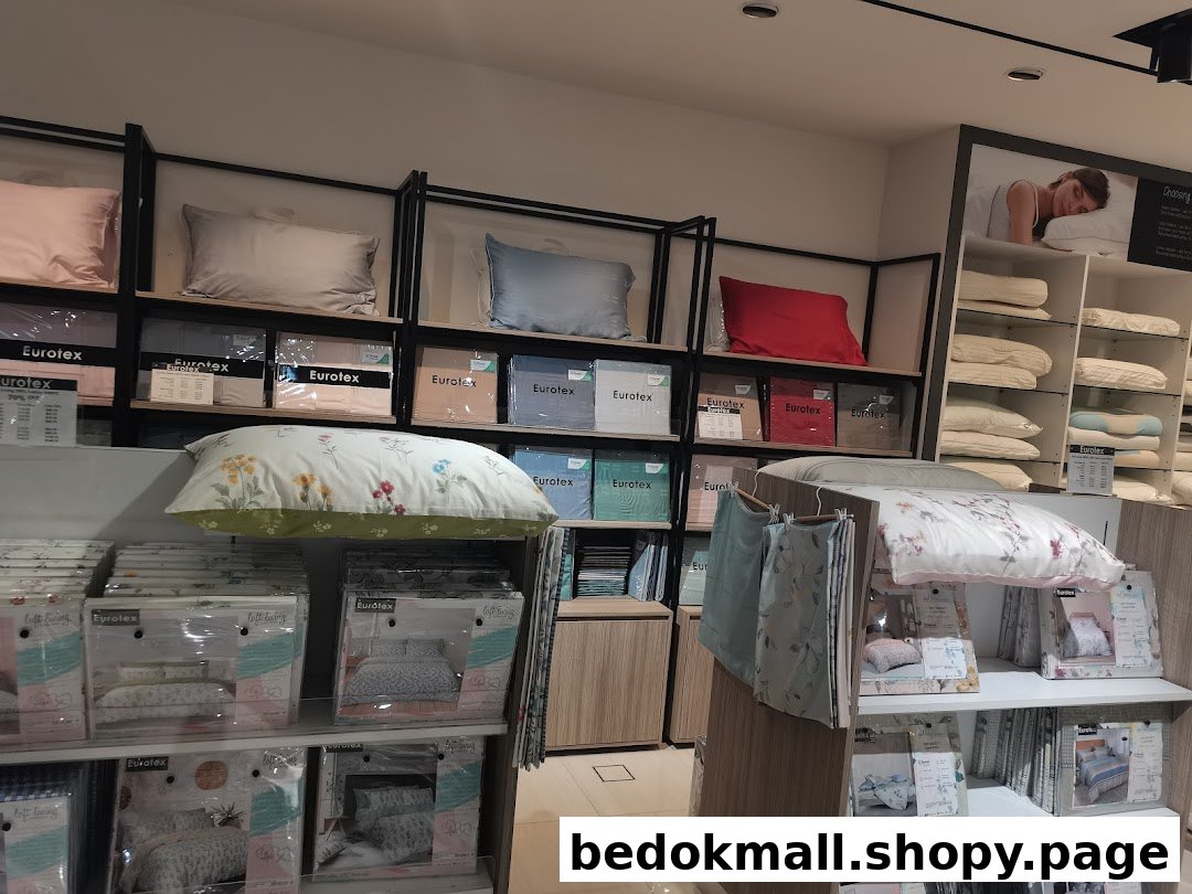 Interior view of a Eurotex bedding shop displaying pillows and packaged sets.