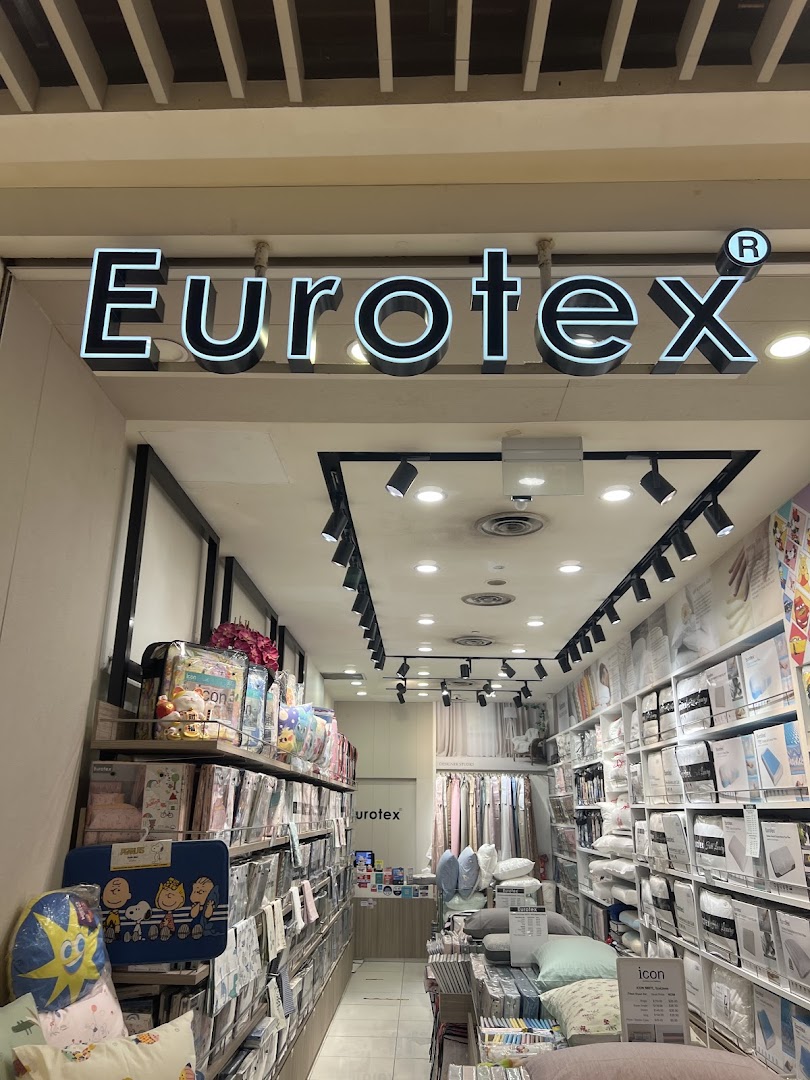 View of the Eurotex shop entrance with its illuminated sign and interior products.