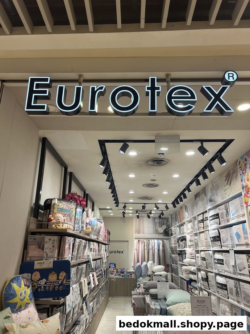 View of the Eurotex shop entrance with its illuminated sign and interior products.