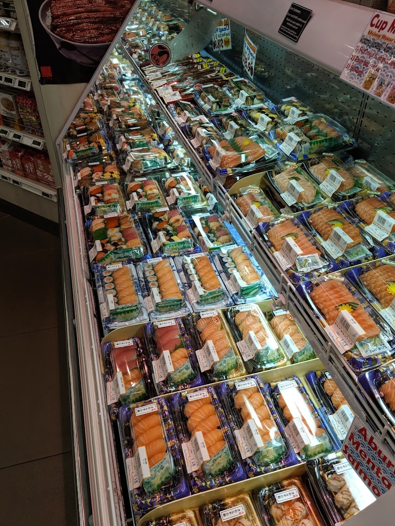 Refrigerated display case filled with various pre-packaged sushi and sashimi.