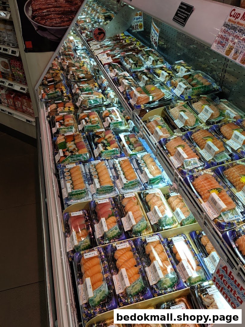Refrigerated display case filled with various pre-packaged sushi and sashimi.