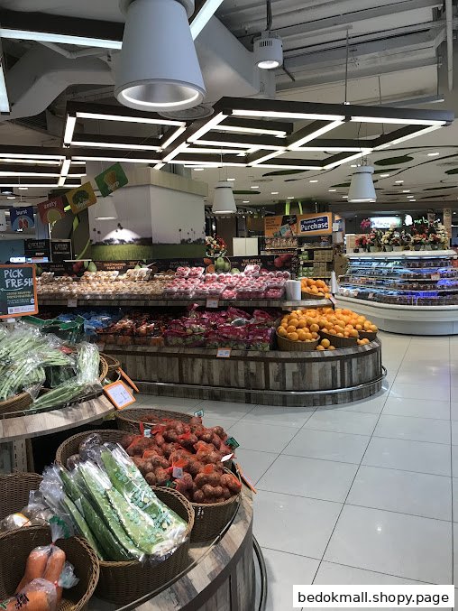 Interior view of a supermarket produce section with fruits and vegetables.