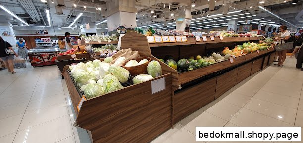 Interior view of a supermarket produce section with fruits and vegetables on display.