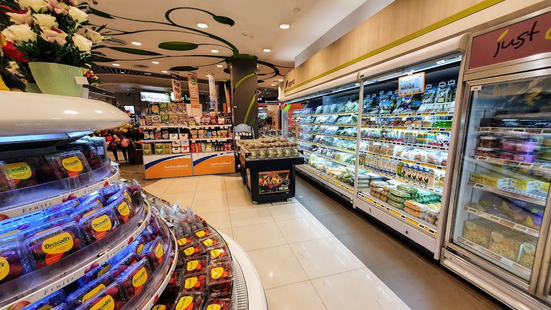 Interior view of a grocery store with produce, refrigerated cases, and shelves.