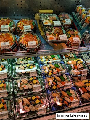 Display case filled with various pre-packaged sushi and Japanese food items.