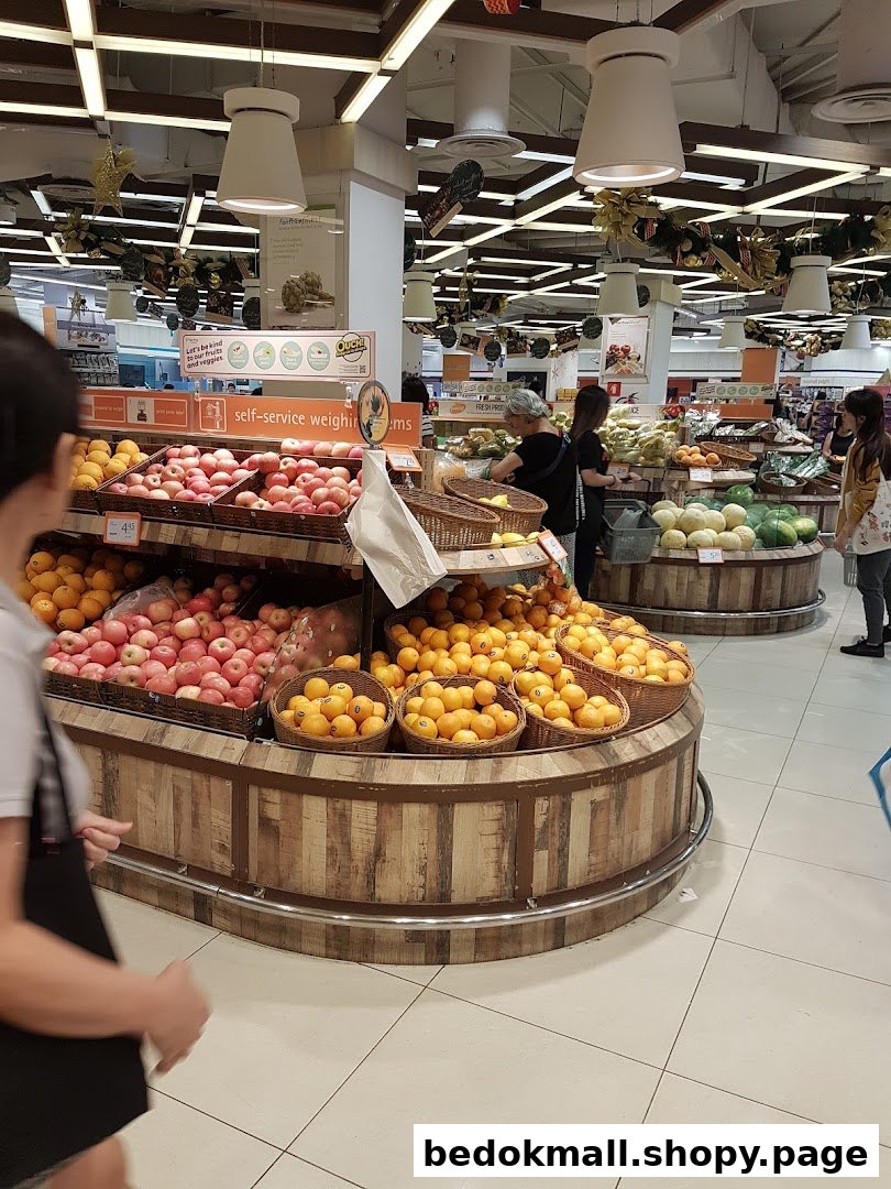 Supermarket interior with large fruit displays and shoppers.