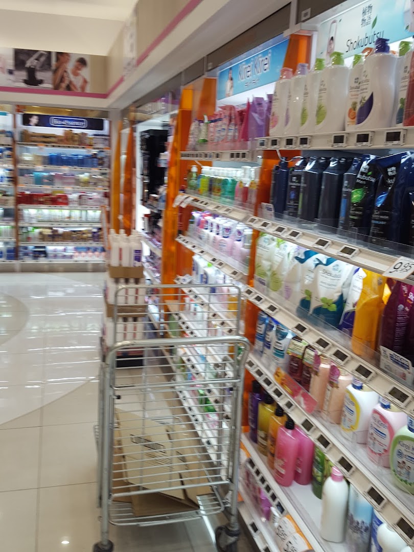 Shop interior with shelves of health and beauty products and a shopping cart.