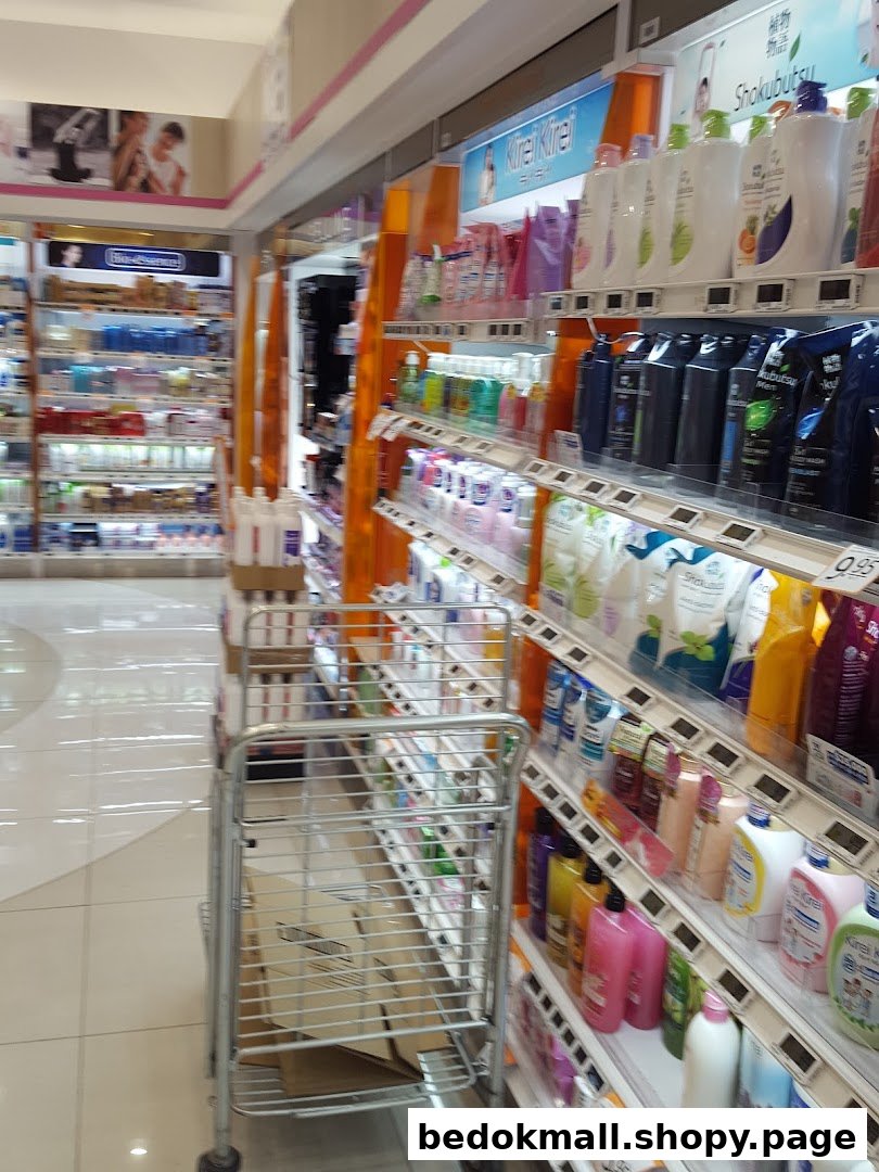 Shop interior with shelves of health and beauty products and a shopping cart.