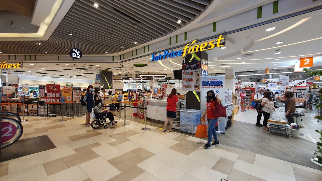 Entrance of a FairPrice Finest supermarket with people and product displays.