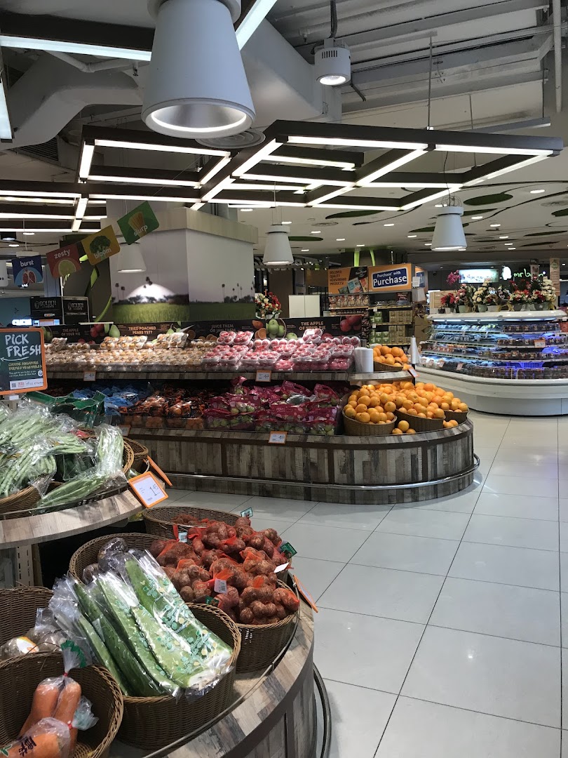 Interior view of a supermarket produce section with fruits and vegetables.