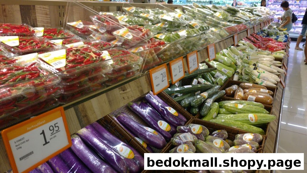 Rows of fresh vegetables and produce displayed in a supermarket aisle.