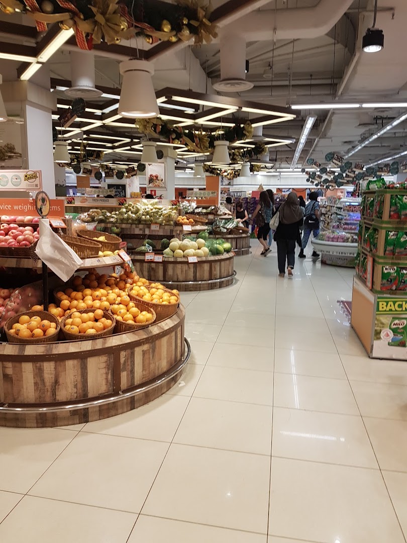 Interior view of a supermarket with fresh produce displays and shoppers.