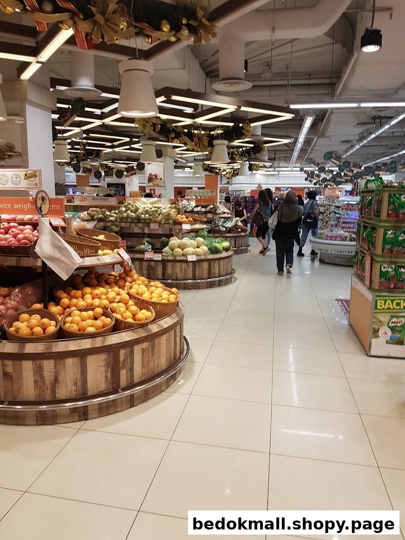 Interior view of a supermarket with fresh produce displays and shoppers.