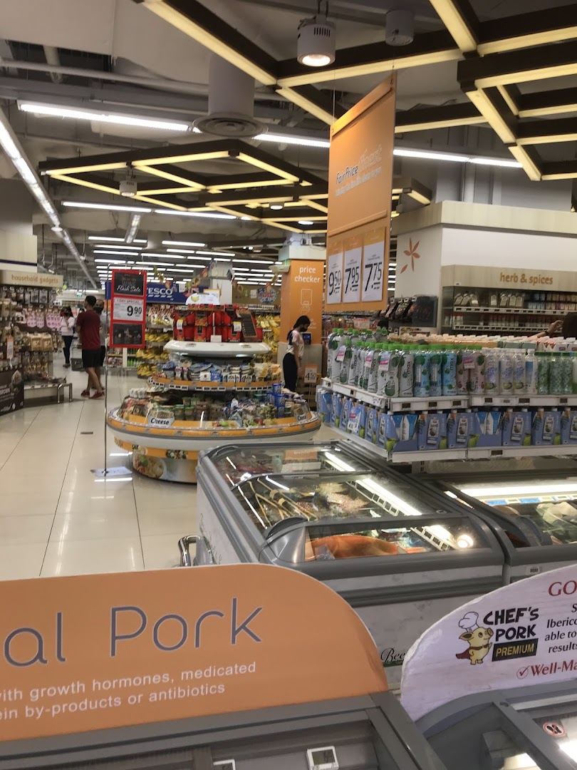 Interior view of a supermarket with aisles, products, freezers, and customers.