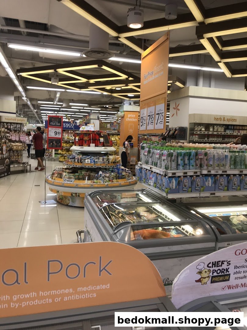 Interior view of a supermarket with aisles, products, freezers, and customers.