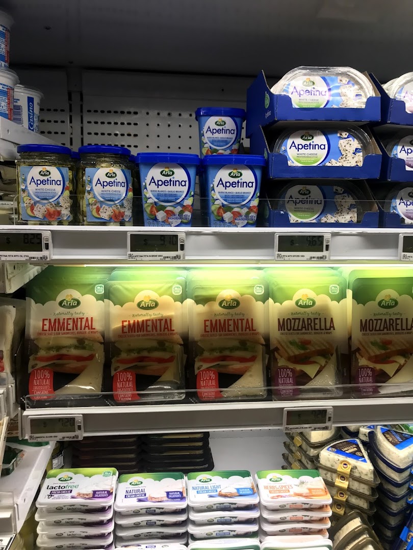 Shelves stocked with various cheese and dairy products in a supermarket.