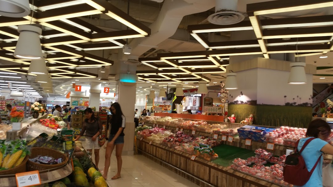 Interior view of a supermarket produce section with shoppers.
