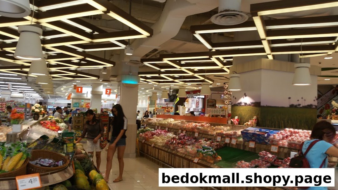 Interior view of a supermarket produce section with shoppers.