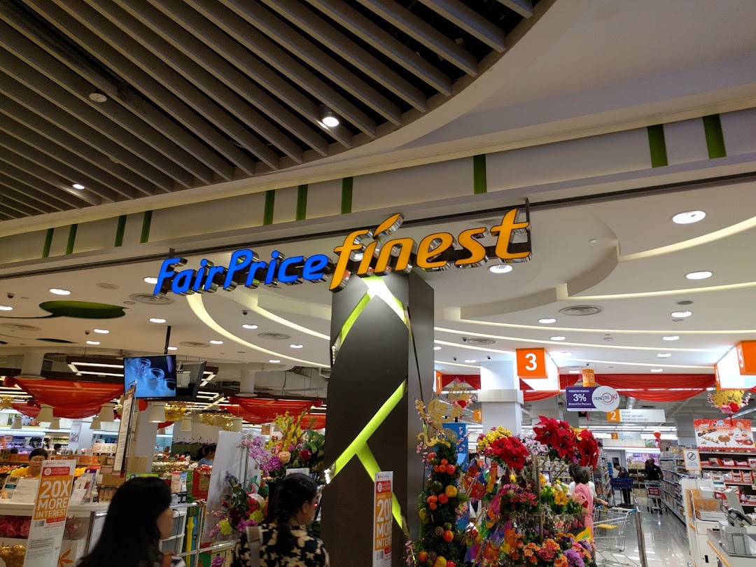 Interior view of FairPrice Finest supermarket with shoppers and festive decorations.