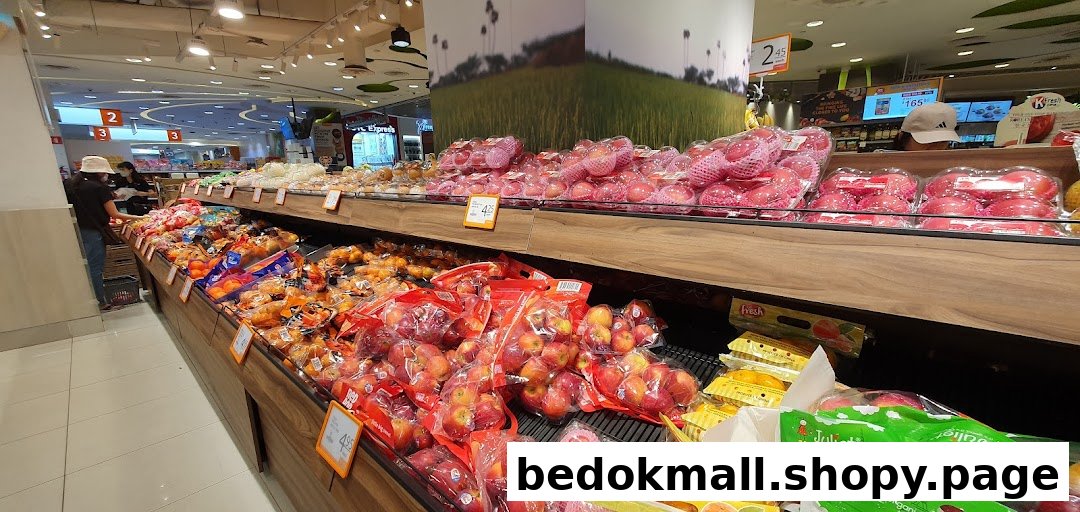 Supermarket interior with extensive fruit displays and shoppers.