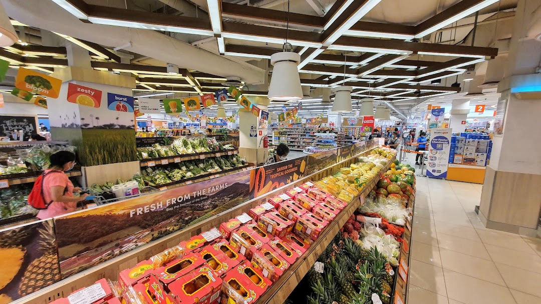 Interior view of a supermarket's fresh produce section with fruits and vegetables.