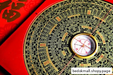 Close-up of a traditional Chinese Fengshui compass and red object.
