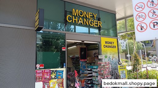 Exterior view of a money changer shop with snacks displayed near the entrance.