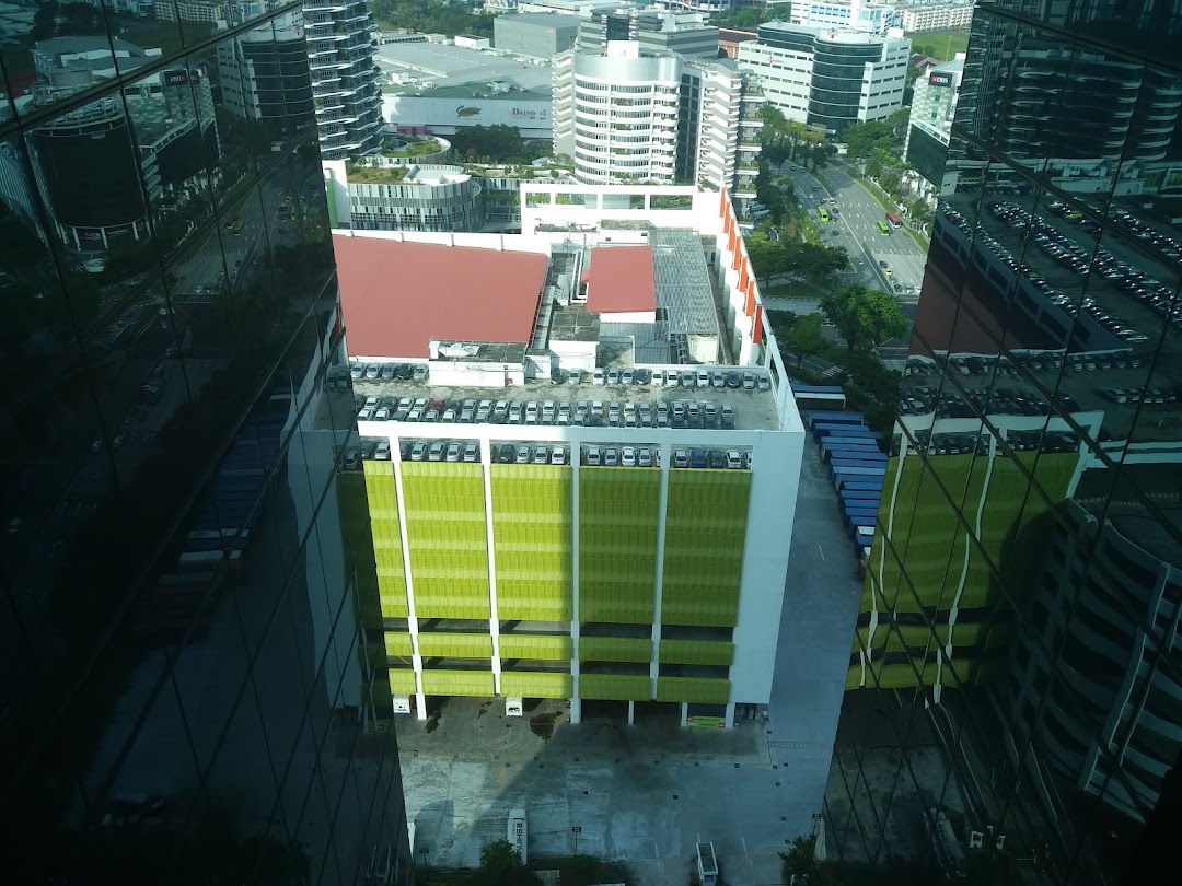 High-angle view of urban landscape with buildings, parking garage, and reflections.