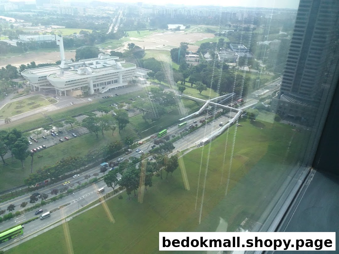 Aerial view of urban landscape with buildings, roads, and green areas.