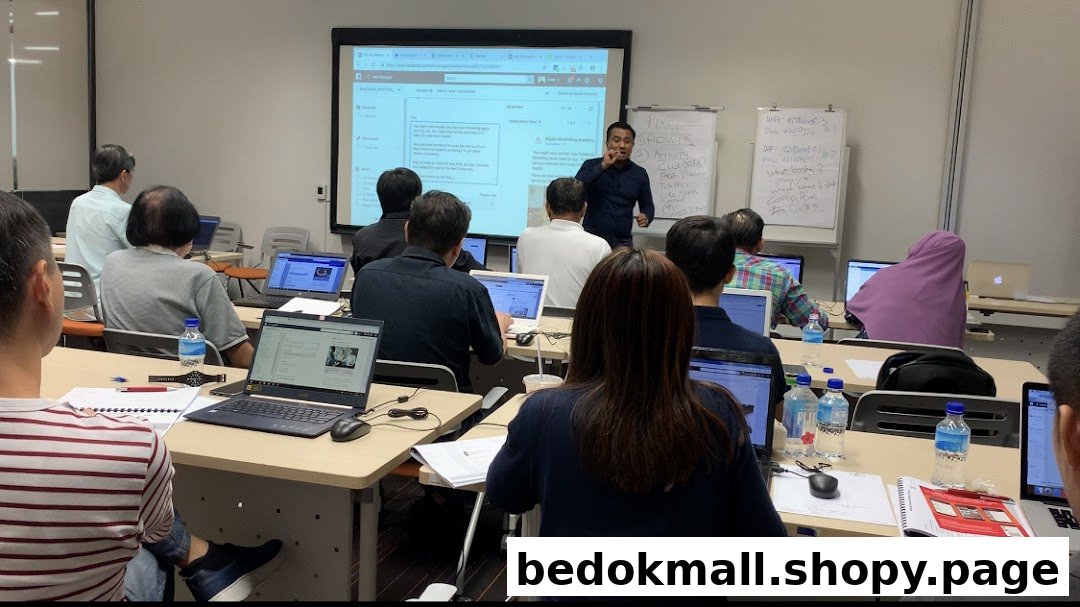 People attending a class or workshop with laptops and a presenter.